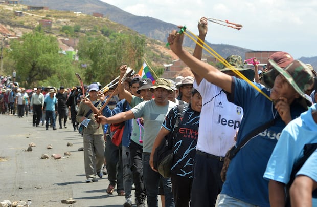 Partidarios del expresidente boliviano Evo Morales muestran sus hondas mientras marchan en Parotani, a 40 kilómetros de Cochabamba, Bolivia, el 29 de octubre de 2024. (Foto FERNANDO CARTAGENA / AFP)